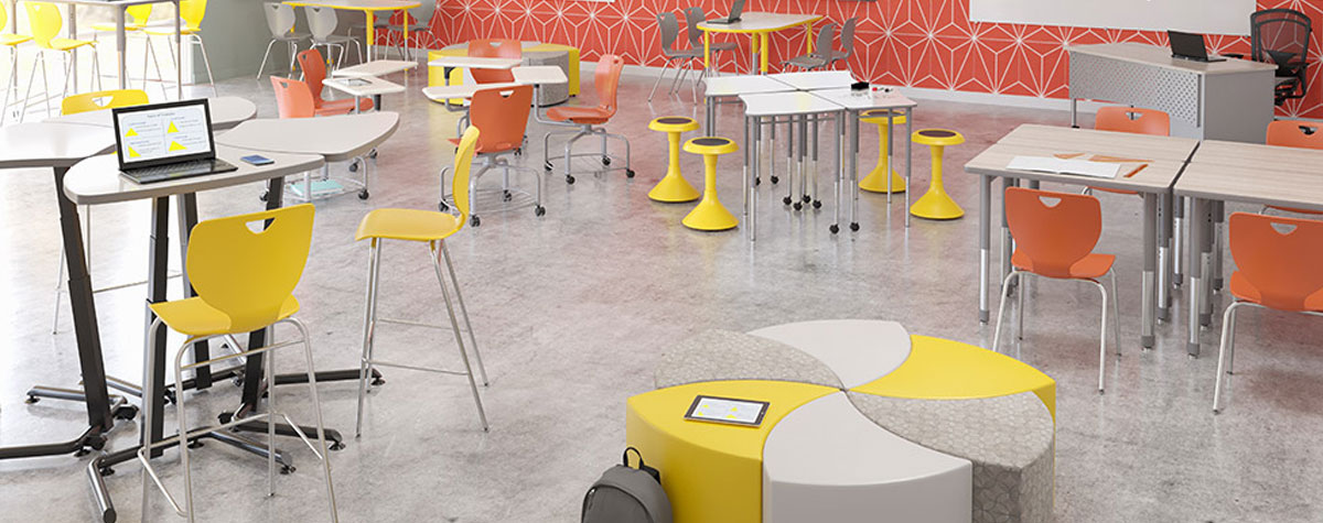 Bright science room with high top tables and soft seating.