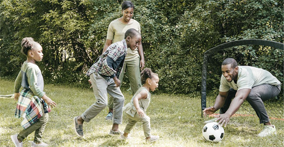 Family playing soccer outside