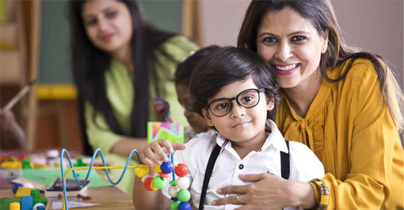 Woman with her arm around a child, both looking at the camera