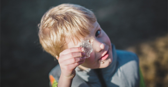 Child looking through a crystal