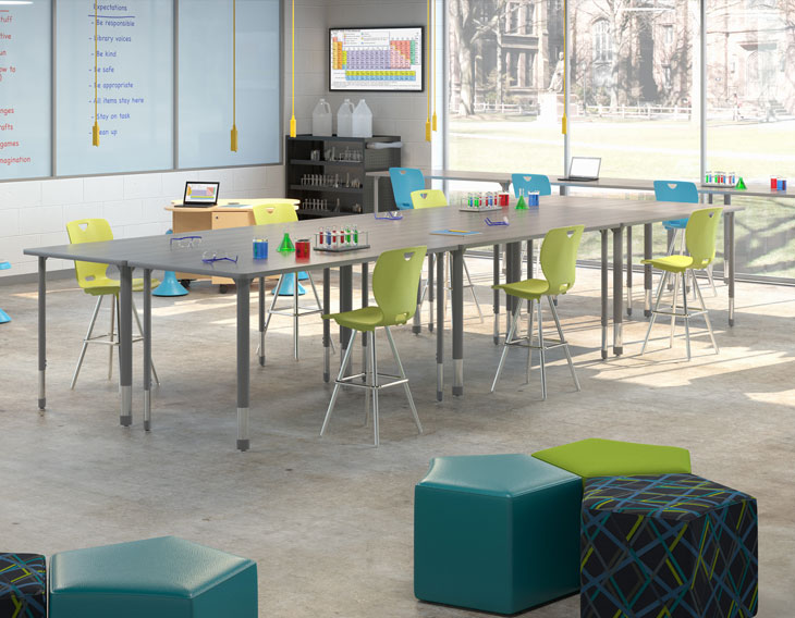 Science room with long rectangular table, student chairs, and science equipment.